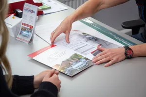 Zwei Menschen vor Fahrschulwagen